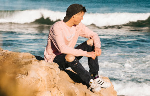 ung man sitter på klippa och tittat ut över havet